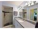 Well-lit bathroom features a walk-in shower with decorative tiles, a wide mirror and granite countertops at 6912 Drewrys Blf # 608, Bradenton, FL 34203