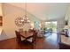 Inviting living room showcases vaulted ceilings, hardwood floors, a dining table, chandelier, and sliding doors to a screened porch at 6912 Drewrys Blf # 608, Bradenton, FL 34203