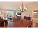 Inviting living room showcases vaulted ceilings, hardwood floors, a dining table, chandelier, and sliding doors to a screened porch at 6912 Drewrys Blf # 608, Bradenton, FL 34203