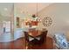Cozy living room area featuring hardwood floors, dining table, chandelier, and an open kitchen with counter seating at 6912 Drewrys Blf # 608, Bradenton, FL 34203