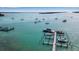 Aerial view of docks and boats on clear blue ocean waters with multiple sailboats anchored offshore on a sunny day at 710 Fox St, Longboat Key, FL 34228