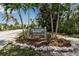 Charming community sign surrounded by palm trees and lush greenery, indicating a historic village in Longbeach, Florida at 710 Fox St, Longboat Key, FL 34228