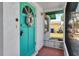 Charming turquoise front door with decorative wreath and covered entry at 710 Fox St, Longboat Key, FL 34228