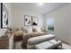 Bright bedroom with a bed between two tables below artwork beside a window at 7742 Ridgelake Cir, Bradenton, FL 34203