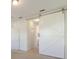 Hallway leads to a bathroom and features a modern sliding barn door and new carpeting at 7742 Ridgelake Cir, Bradenton, FL 34203