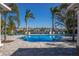 Sparkling community pool with comfortable lounge chairs, framed by palm trees and distant neighborhood views at 7742 Ridgelake Cir, Bradenton, FL 34203