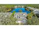 Aerial view showcasing a lakefront home with mature trees and lush landscaping at 7742 Whitebridge Gln, University Park, FL 34201