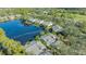 Aerial view of homes bordering a tranquil lake in a lush, green community at 7742 Whitebridge Gln, University Park, FL 34201