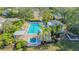 Aerial view of a sparkling community pool and hot tub surrounded by palm trees and cozy lounging areas at 7742 Whitebridge Gln, University Park, FL 34201