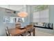 Dining area with pendant lighting and view into the kitchen, creating a welcoming space at 7742 Whitebridge Gln, University Park, FL 34201
