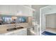 Contemporary kitchen features a stainless steel sink, white cabinets, and a pass-through window at 7742 Whitebridge Gln, University Park, FL 34201