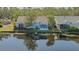 Water view showcasing a home with a screened lanai, beautiful trees, and a serene reflection on the water at 7742 Whitebridge Gln, University Park, FL 34201