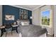 Cozy bedroom with a desk, gray bedding, and a window offering natural light at 9128 Radiant Cir, Sarasota, FL 34241