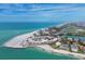 Expansive aerial view of beachfront condo with pristine sandy beach, blue ocean waters, and lush coastal landscaping at 100 Sands Point Rd # 225, Longboat Key, FL 34228
