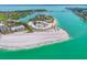 Beautiful aerial view of circular condo on a pristine beach with turquoise water and gorgeous waterfront surroundings at 100 Sands Point Rd # 225, Longboat Key, FL 34228