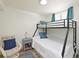 Cozy bedroom featuring bunk beds, side table with lamp, and chair with accent pillow at 100 Sands Point Rd # 225, Longboat Key, FL 34228