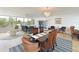 Bright, open concept living space with dining area and floor-to-ceiling windows overlooking tropical landscaping at 100 Sands Point Rd # 225, Longboat Key, FL 34228