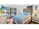 Comfortable bedroom with balcony access, TV, wood floors, and a calming color palette at 1113 Lake House Cir # C110, Sarasota, FL 34242