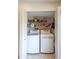 Functional laundry closet with stacked washer and dryer, and shelving for storage at 1113 Lake House Cir # C110, Sarasota, FL 34242