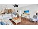 Bright living room with white sofa, wood floors, and a ceiling fan; an open design connects to the upper level at 1113 Lake House Cir # C110, Sarasota, FL 34242