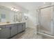 Modern bathroom featuring double sinks, quartz countertop, walk-in glass shower, and wood-look tile floors at 12130 Seabrook Ave, Bradenton, FL 34211