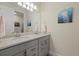 Bathroom with double vanity featuring gray cabinets, gold hardware, and a large mirror above at 12130 Seabrook Ave, Bradenton, FL 34211