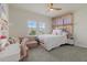 Bright bedroom featuring a cozy seating area, unique window-themed headboard, and a ceiling fan at 12130 Seabrook Ave, Bradenton, FL 34211