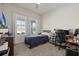 Bright bedroom with a comfortable bed, large windows with white curtains, and a functional desk area at 12130 Seabrook Ave, Bradenton, FL 34211