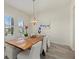 A modern dinette area with a wooden table, white chairs, and large windows with wooded views at 12130 Seabrook Ave, Bradenton, FL 34211