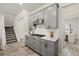 A stylish kitchen featuring gray cabinets, granite countertops, and stainless steel appliances with stairway at 12130 Seabrook Ave, Bradenton, FL 34211