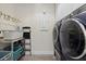 Laundry room with a washer, dryer, shelving, and hanging rack for efficient organization at 12130 Seabrook Ave, Bradenton, FL 34211