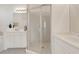 Bright bathroom featuring a glass-enclosed shower, double sinks, and white cabinetry at 1311 Triano Cir # 1311, Venice, FL 34292