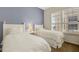 Bedroom features two twin beds, blue accent wall, and a large window at 1311 Triano Cir # 1311, Venice, FL 34292