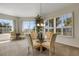 Bright dining space features a glass-top table, elegant chairs, and large windows at 1311 Triano Cir # 1311, Venice, FL 34292