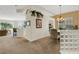 Open-concept dining area with elegant chandelier, carpet flooring, and architectural details at 1311 Triano Cir # 1311, Venice, FL 34292
