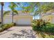 Exterior view of the home's garage with lush landscaping and brick driveway at 1311 Triano Cir # 1311, Venice, FL 34292