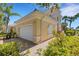 Side view of home featuring a two-car garage, tile roof, and decorative window at 1311 Triano Cir # 1311, Venice, FL 34292