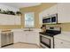 This kitchen has white cabinets and stainless steel appliances and light yellow walls at 1311 Triano Cir # 1311, Venice, FL 34292