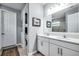 Well-lit bathroom featuring double sinks, white cabinetry, and a modern design with gray walls at 14616 20Th E St, Parrish, FL 34219