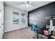 The bedroom features a desk, chair, and dark accent wall with a 