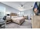 Spacious primary bedroom boasts a king bed, soft gray walls, a ceiling fan and an en-suite bathroom at 14616 20Th E St, Parrish, FL 34219