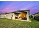 Rear exterior view showing the covered patio, lawn, and well-maintained backyard with a black fence at 14616 20Th E St, Parrish, FL 34219