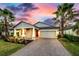 Charming single-story home with a brick driveway and well-maintained landscaping with palm trees at 14616 20Th E St, Parrish, FL 34219