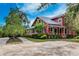 Charming red two-story home with wrap-around porch and well-maintained landscaping at 14616 20Th E St, Parrish, FL 34219