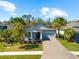 Charming single-story home with a well-manicured lawn, a paver driveway, and lush landscaping at 14616 20Th E St, Parrish, FL 34219