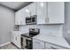 Close-up of a kitchen showcasing white cabinets, quartz countertops, and modern stainless steel appliances at 14616 20Th E St, Parrish, FL 34219
