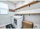 Bright laundry room features a washer, dryer, and open shelving at 14616 20Th E St, Parrish, FL 34219