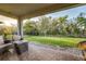 Outdoor patio with furniture overlooking the landscaped backyard and black fence at 14616 20Th E St, Parrish, FL 34219