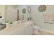 Bright bathroom featuring a white vanity, quartz countertop, and coastal decor at 1649 Burgos Dr, Sarasota, FL 34238