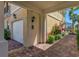 The side of this home features a brick carport, a two-car garage, and tropical landscaping at 1649 Burgos Dr, Sarasota, FL 34238
